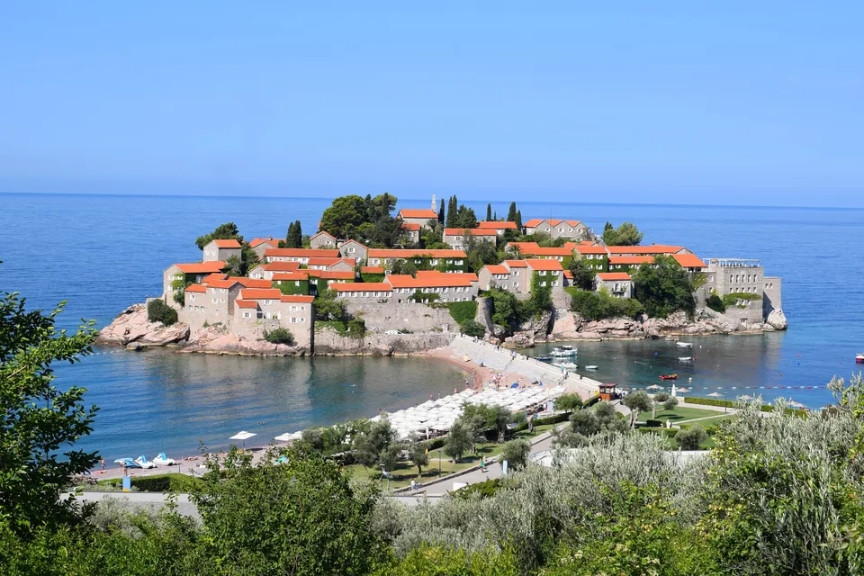Ostrvce Sveti Stefan sa crvenim krovovima povezano uskim pješčanim sprudom sa obalom
