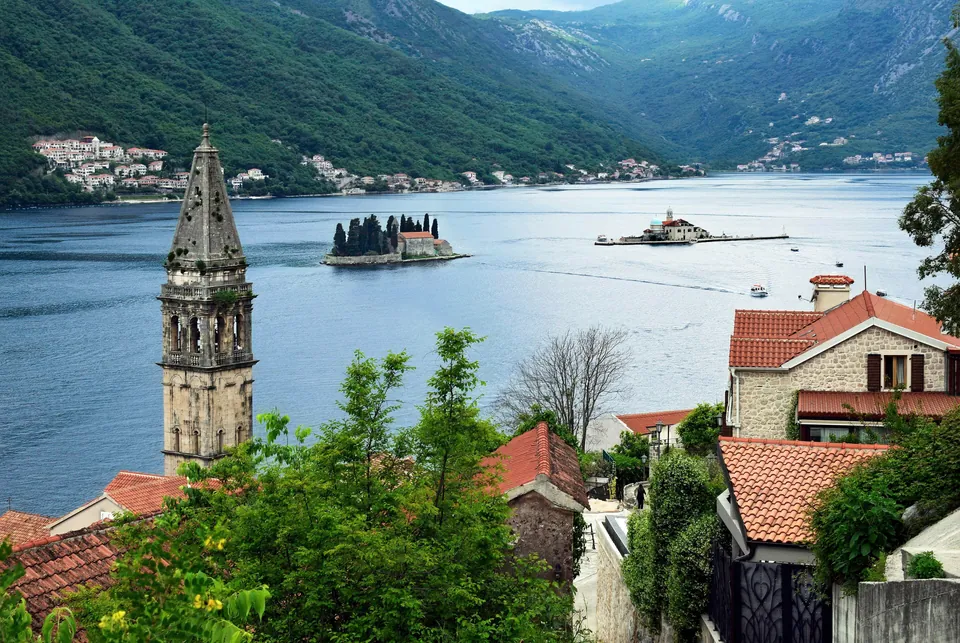 Pogled iz Perasta preko krovova na ostrva Gospu od Škrpjela i Sveti Đorđe u zalivu