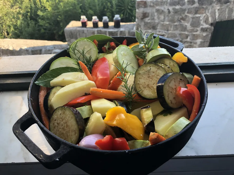 Cast iron pan of garden vegetables on stone terrace