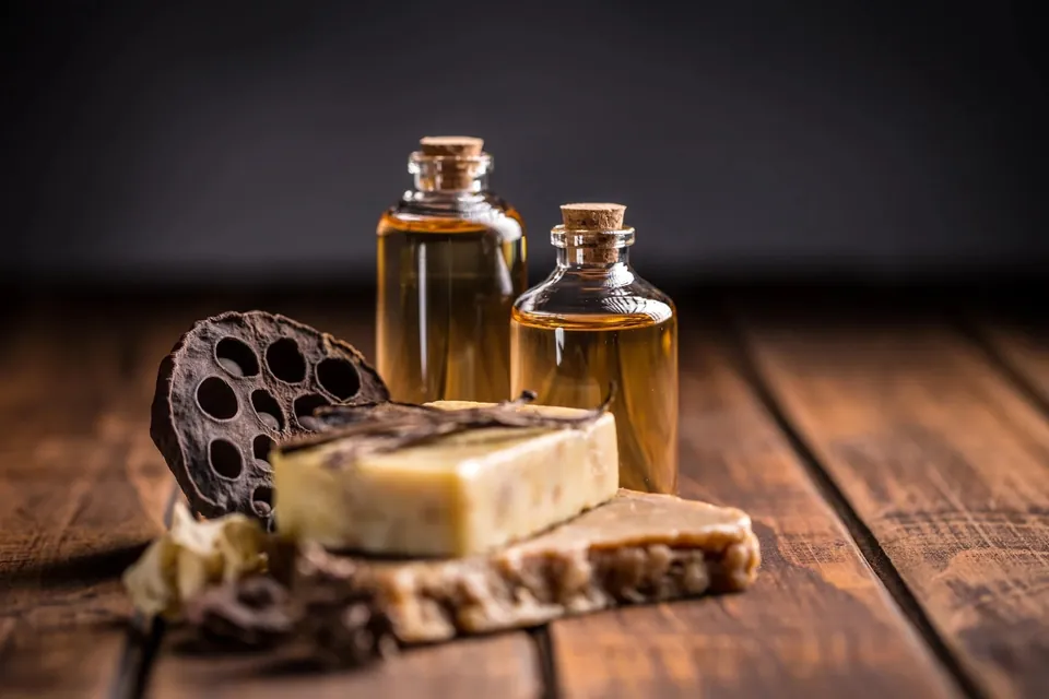 Small oil bottles and olive soap arranged on a wooden board