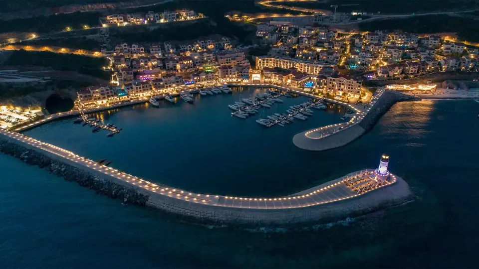 Marina Village at dusk with lighthouse breakwater and illuminated waterfront