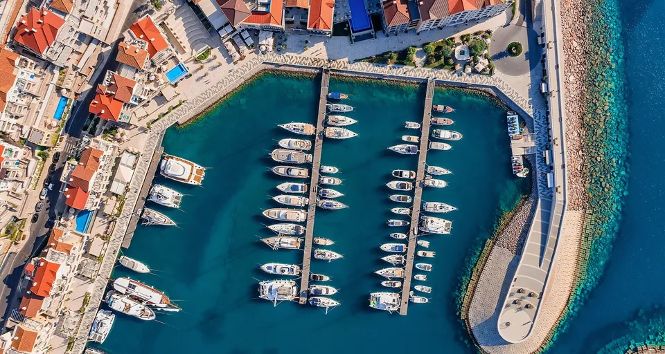 Aerial view of marina pontoons and terracotta-roofed village