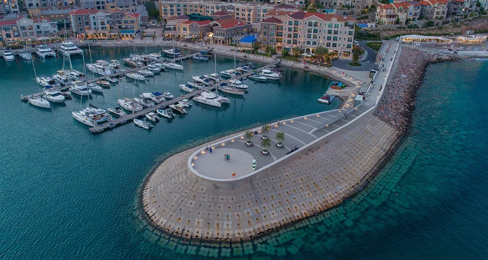 Curved stone breakwater and lighthouse seen from above