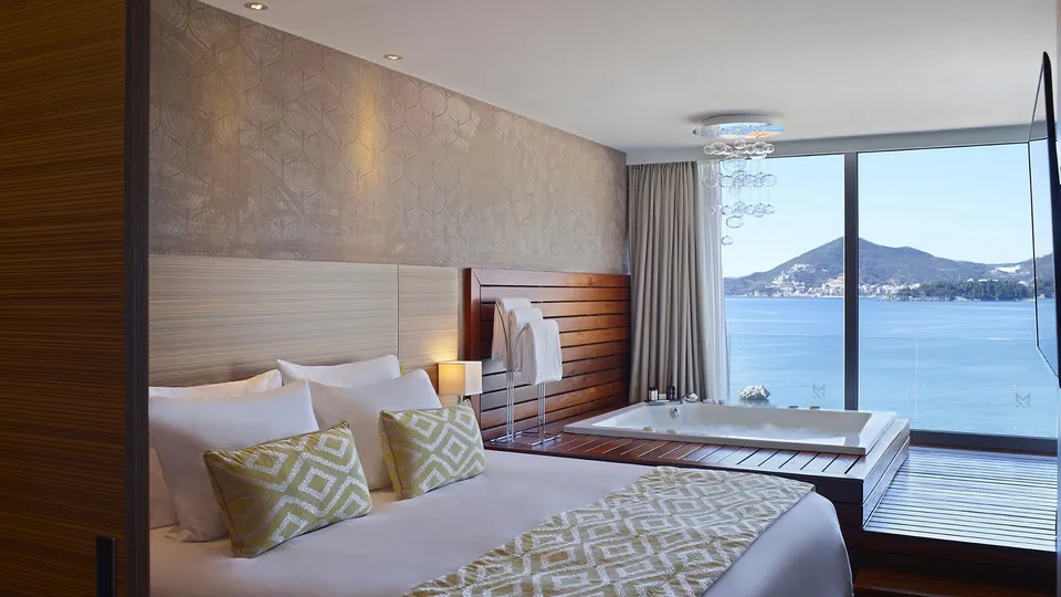 Suite bedroom with sea-facing jacuzzi and coastal view