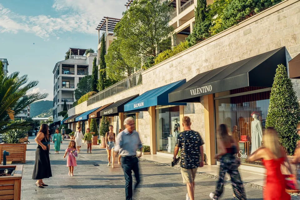 Boutique-lined shopping promenade with people walking