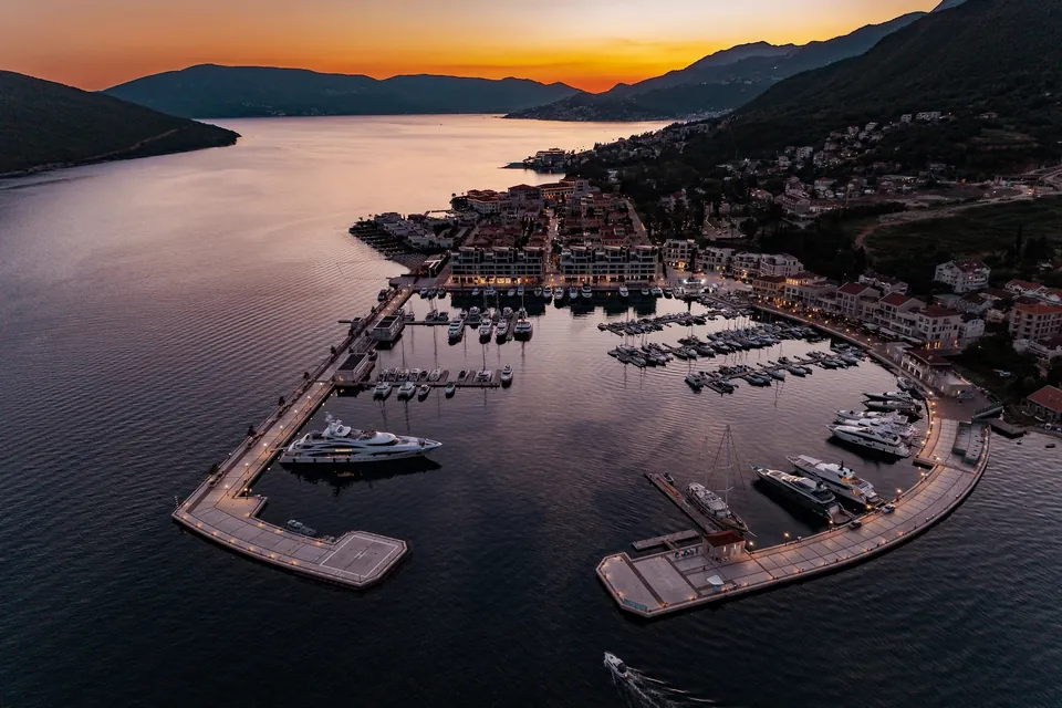 Marina and terracotta-roofed village at dusk from above