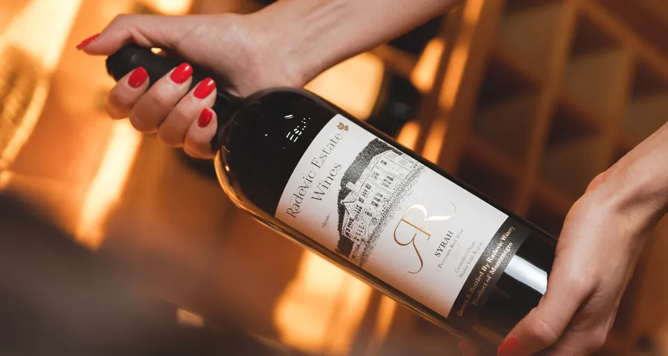 The estate Syrah held to the light, the label carrying a drawing of the house
