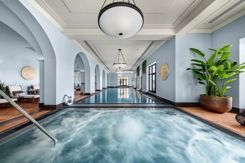 The indoor pool under a run of arches, with the jacuzzi in the foreground