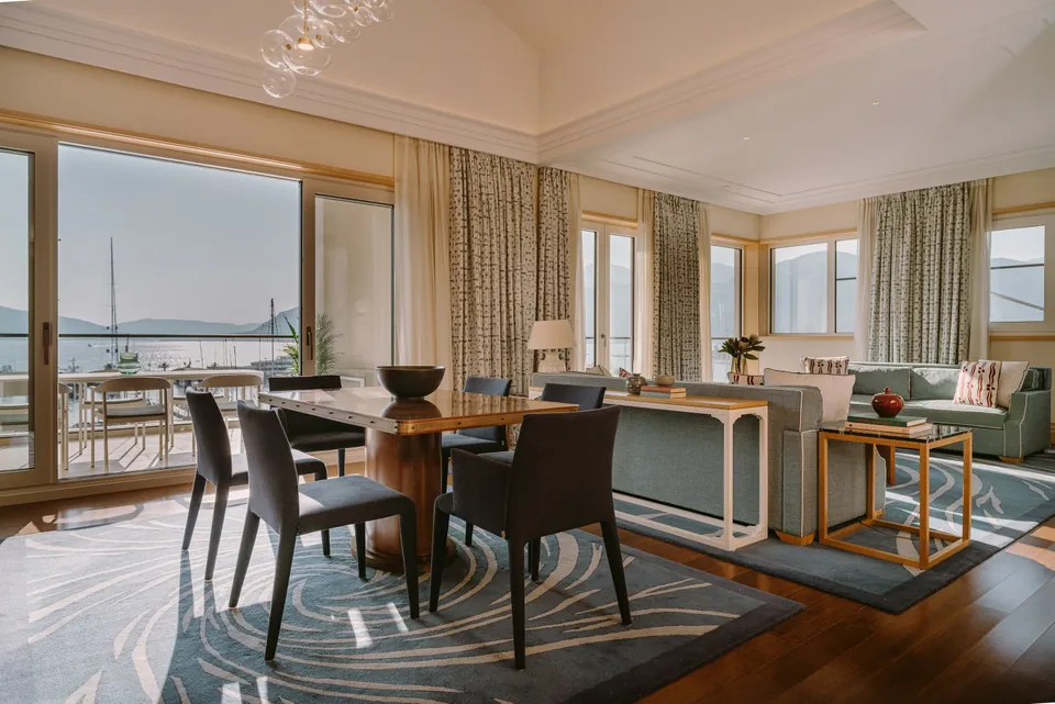 A suite living room opening to the marina and the mountains beyond