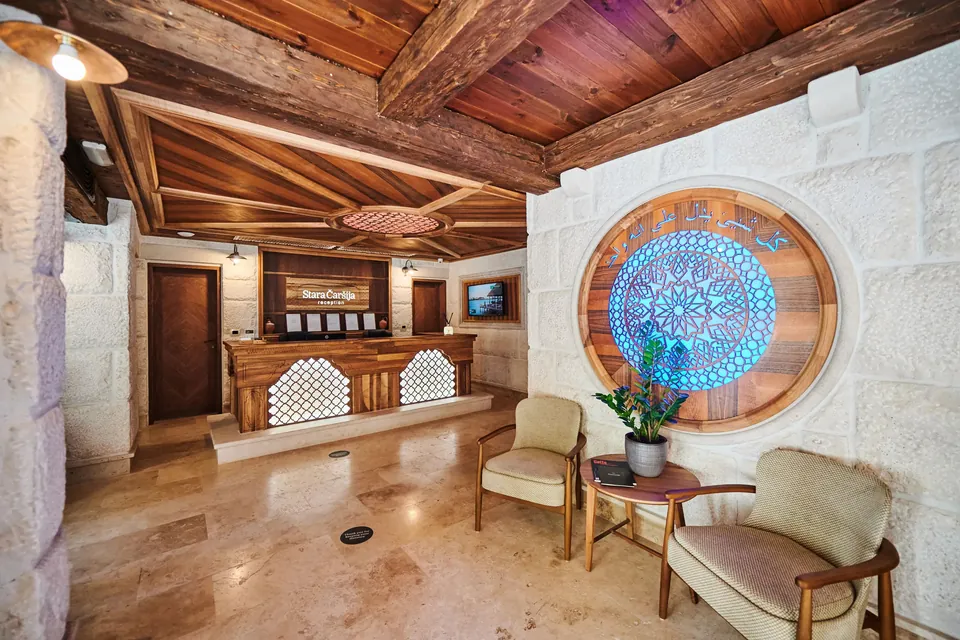 The reception hall in stone and timber, with a round stained glass window in blue