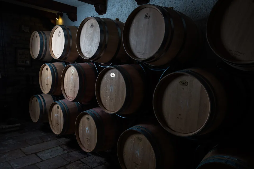Oak barrels stacked inside the old stone cellar