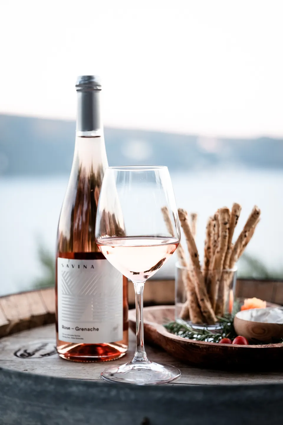 Rosé glass and wine bottle on a barrel table