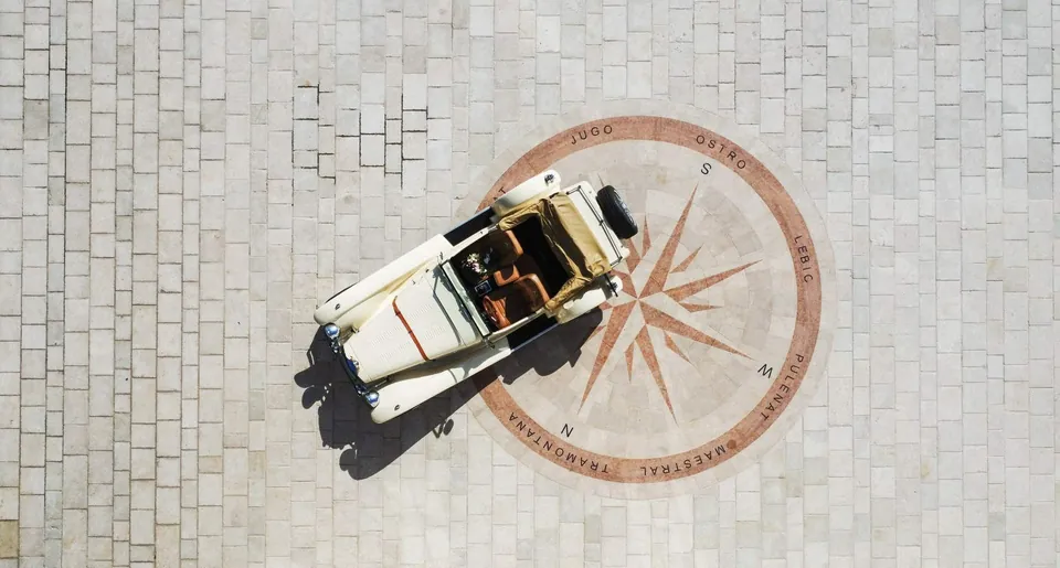 Vintage open top car on a compass rose mosaic