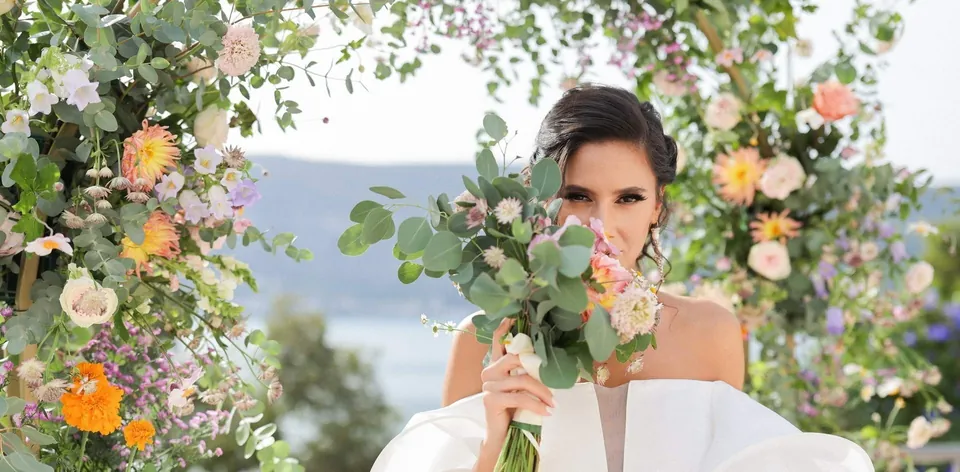 Bride behind a wildflower bouquet overlooking Boka Bay